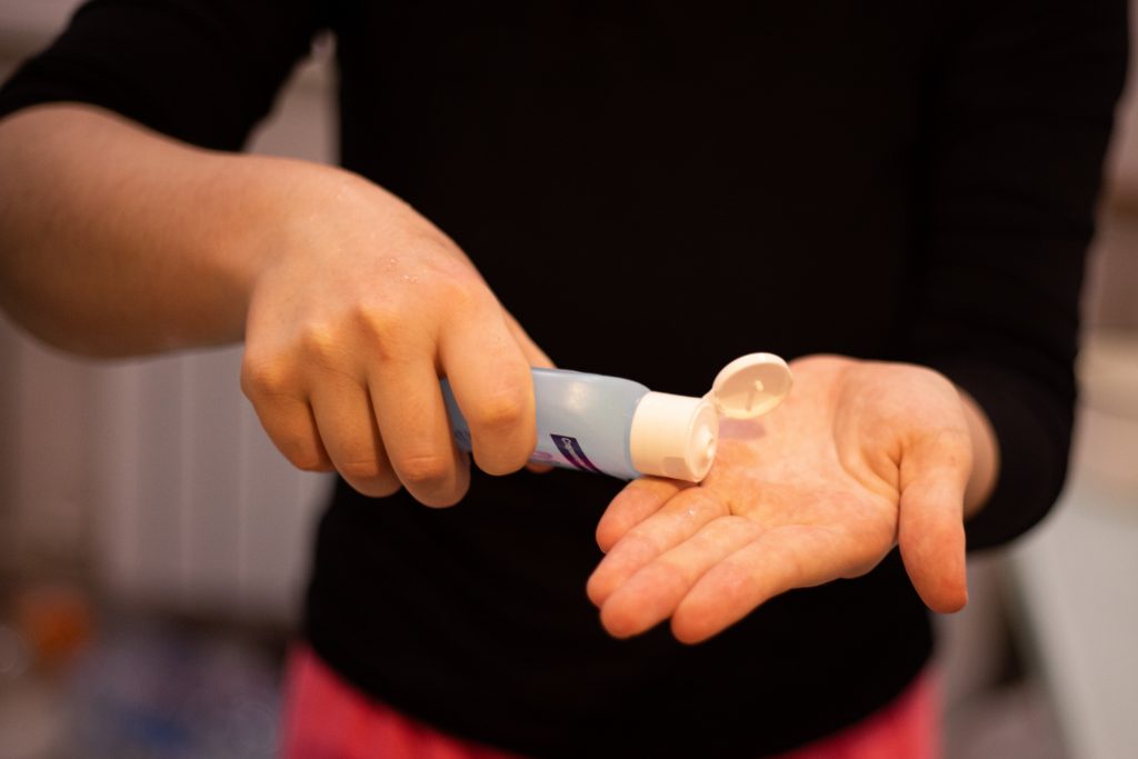 Image of person putting on hand sanitizer to prevent the spread of covid-19